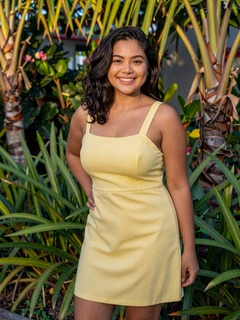 Filipino woman in yellow sundress smiling in tropical garden on dating profile