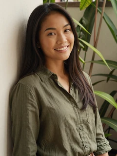 Vietnamese woman in olive linen shirt with natural smile for international dating